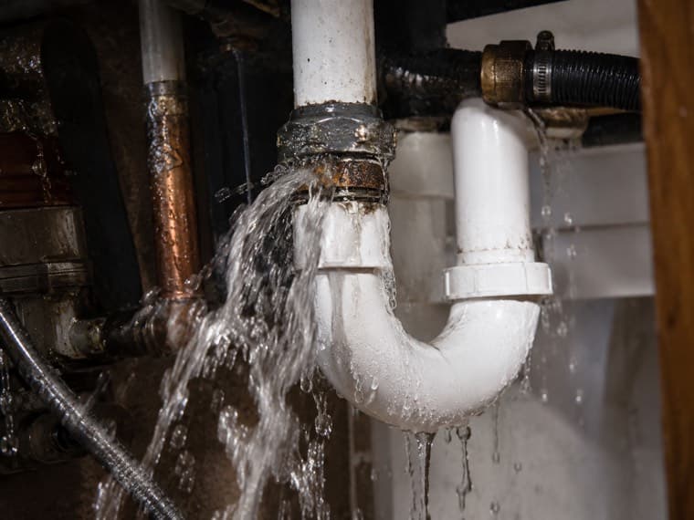 Water spraying from a failed pipe joint during an emergency call-out.