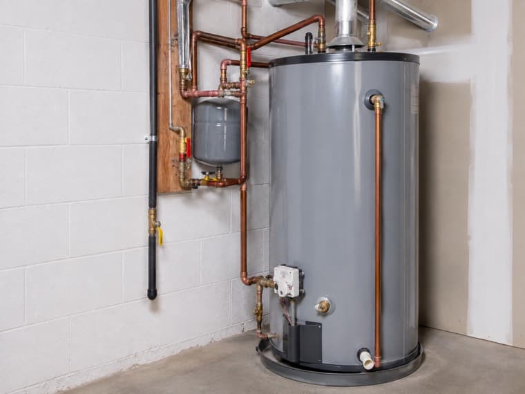 A technician working on the controls of a residential water heater.
